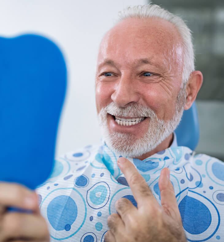 Senior man looking the teeth in the mirror