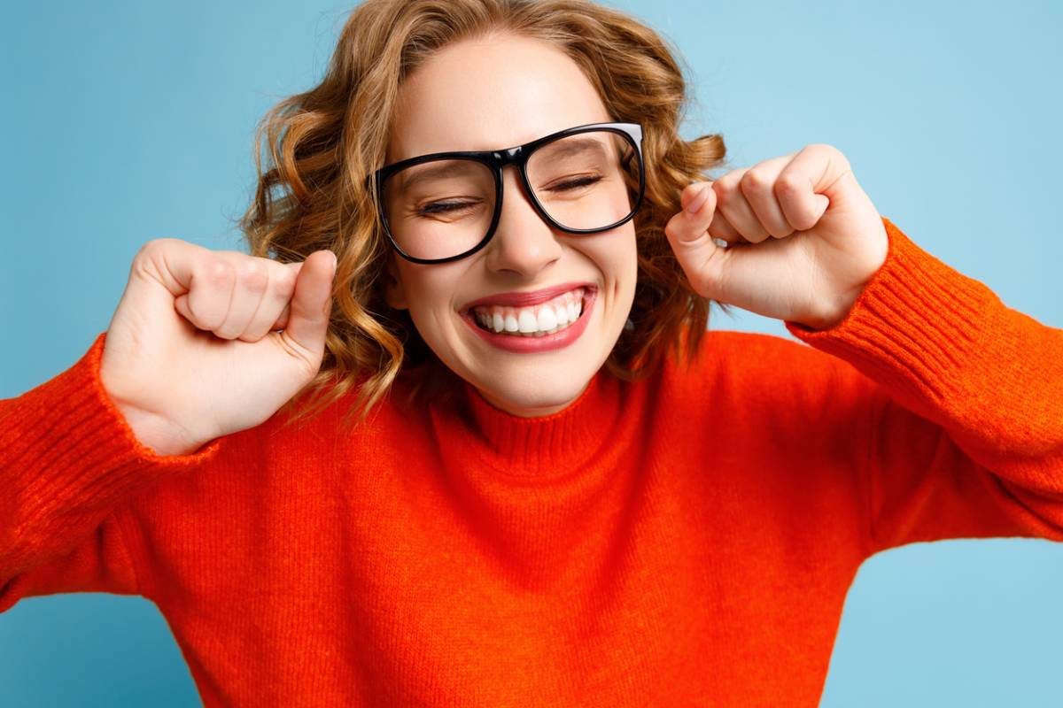 Woman smiling because she is caring for her dental veneers